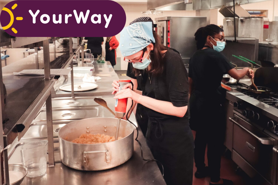 Two women work inside a culinary learning kitchen. The YourWay logo appears in the top corner.